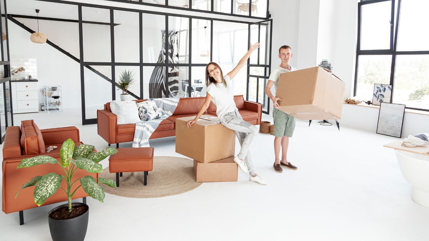 Two movers carrying office furniture outside a building in Dubai, UAE.