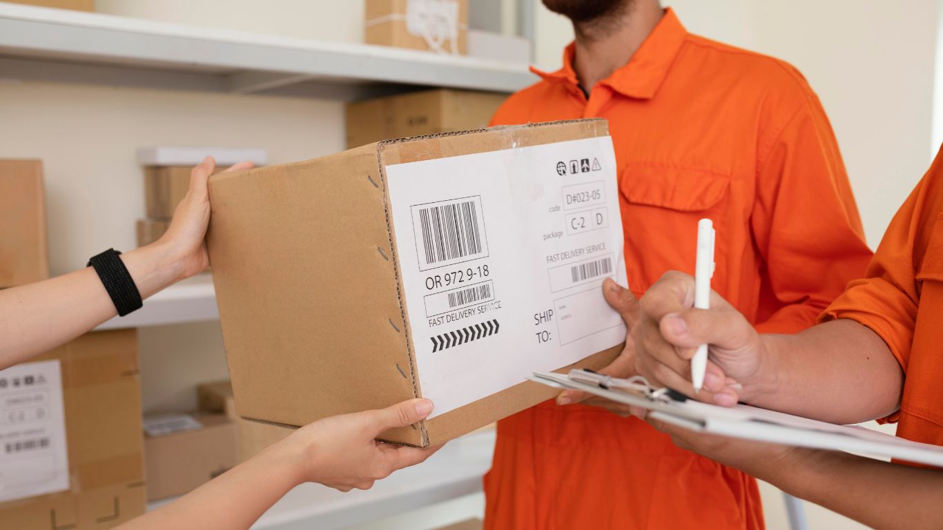 Two movers loading boxes into a moving truck.